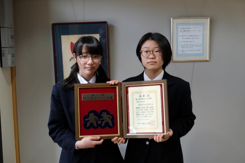 賞状と盾を持つ生徒会長の櫻井乃綾さん(左)と副会長の金谷紅さん(右)
